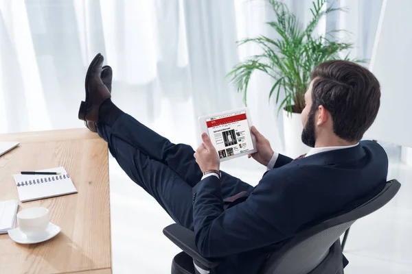 Vista lateral del hombre de negocios utilizando tableta en el lugar de trabajo en la oficina - foto de stock