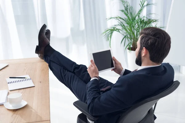 Vista lateral del hombre de negocios utilizando tableta en el lugar de trabajo en la oficina - foto de stock