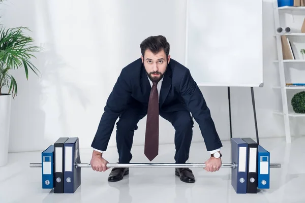 Geschäftsmann im Anzug Gewichtheben Ordner im Büro — Stockfoto