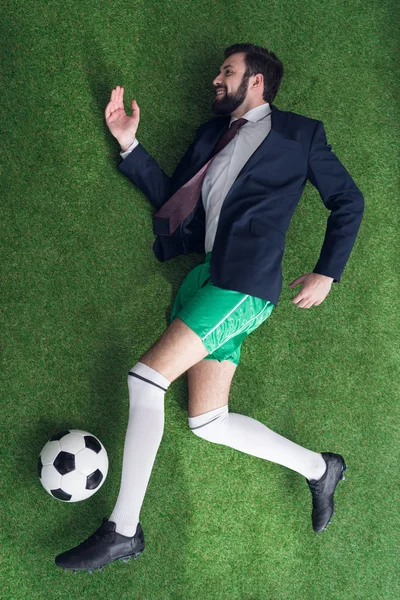 Vista aérea del hombre de negocios jugando al fútbol en el césped verde - foto de stock