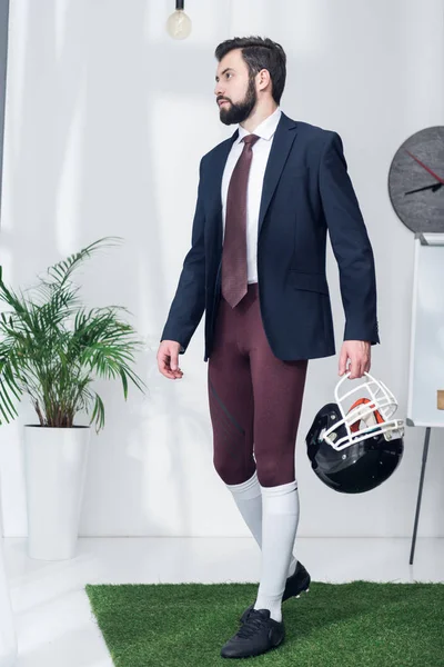 Jeune homme d'affaires avec casque de rugby au bureau — Photo de stock