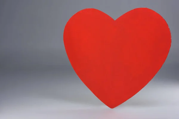 Sinal de coração vermelho simples no cinza — Fotografia de Stock