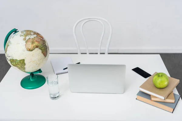 Teachers workplace with laptop and and education objects — Stock Photo