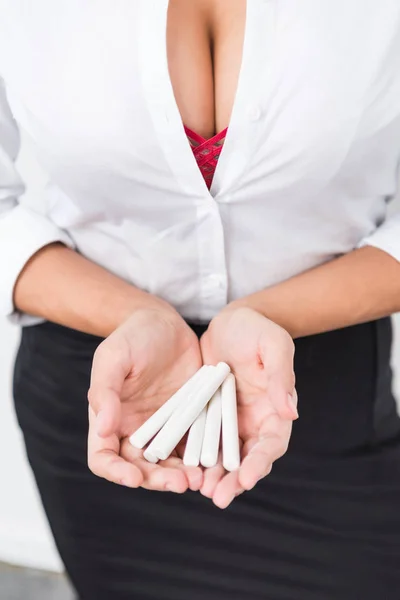 Cropped shot of woman in unbuttoned shirt holding chalk pieces — Stock Photo