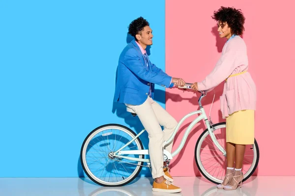 Lovely young couple hugging each other on pink and blue background — Stock Photo