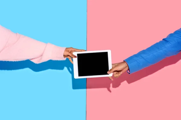 Schnappschuss von afrikanisch-amerikanischem Paar, das Tablette gegen rosa und blaue Wand hält — Stockfoto