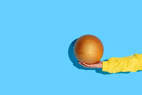 Imagen recortada de la mano del hombre con pelota de baloncesto en la mano - foto de stock