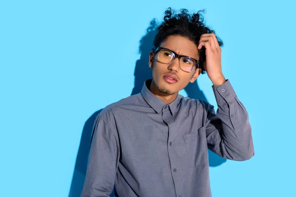 Jovem afro-americano pensativo homem no fundo azul — Fotografia de Stock