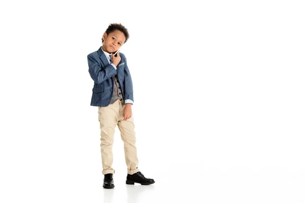 Adorable african american kid talking by smartphone on white — Stock Photo
