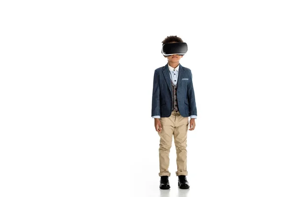 Adorável criança afro-americana de pé com fone de ouvido realidade virtual em branco — Fotografia de Stock