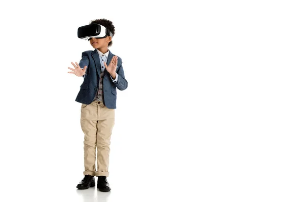 Adorable enfant afro-américain toucher quelque chose avec casque de réalité virtuelle sur blanc — Photo de stock