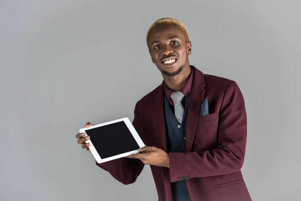 Homme africain souriant tenant tablette numérique dans les mains isolées sur gris — Photo de stock