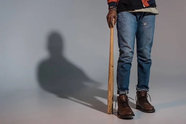 Teilansicht eines Mannes, der sich auf Baseballschläger stützt — Stockfoto