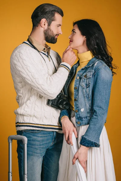 Attractive couple looking at each other isolated on yellow — Stock Photo