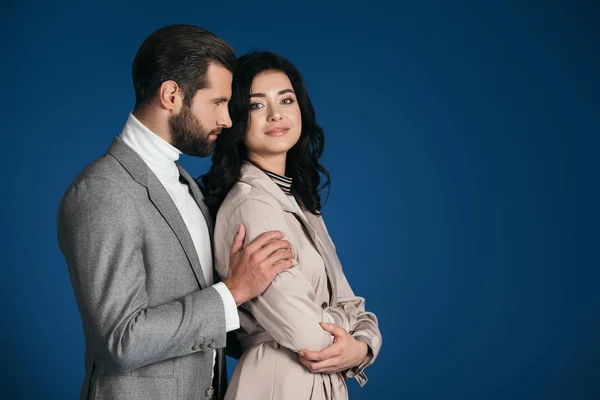 Boyfriend hugging girlfriend isolated on blue — Stock Photo