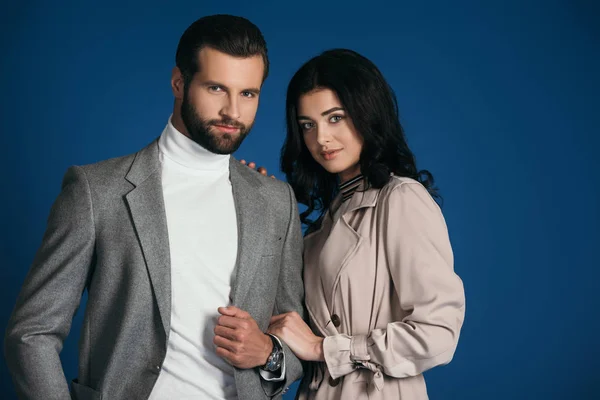 Attractive couple standing and looking at camera isolated on blue — Stock Photo