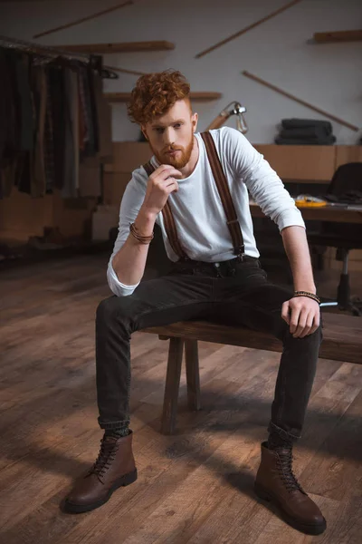 Full length view of handsome stylish young male fashion designer sitting and looking at camera — Stock Photo