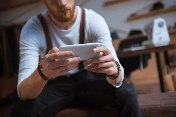 Vista de cerca de un joven con estilo usando un teléfono inteligente - foto de stock