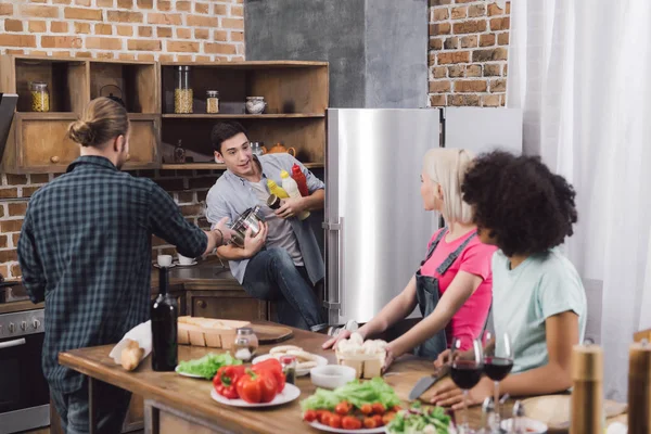 Mann holt Soßen aus Kühlschrank in Küche — Stockfoto