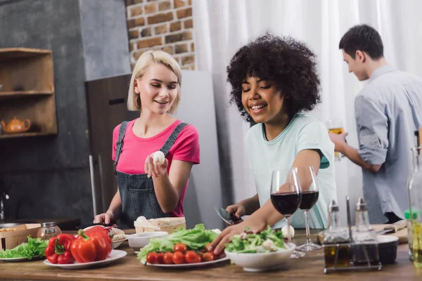 Lächelnde multiethnische Mädchen kochen in der Küche — Stockfoto