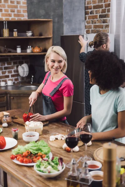 Smiling multiethnic girls cooking in kitchen — Stock Photo