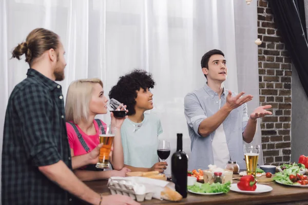 Multiethnic friends looking how friend throwing up mushrooms — Stock Photo