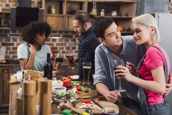 Hombres abrazando chica durante fiesta en cocina - foto de stock