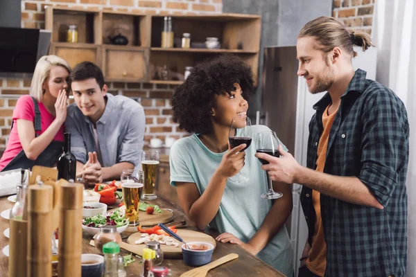 Multiethnisches Paar klirrt mit Brille und Freunde tratschen — Stockfoto