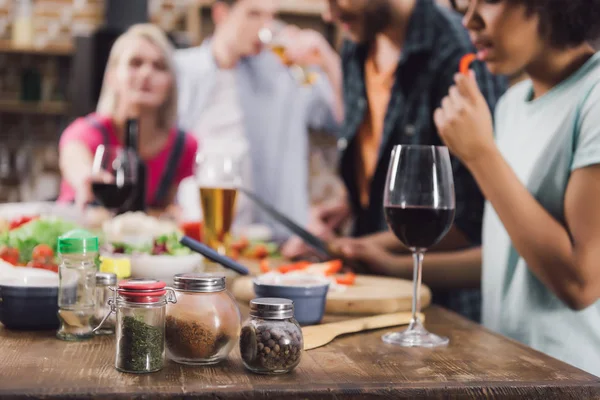 Cropped image of multiethnic friends drinking alcohol and eating food — Stock Photo