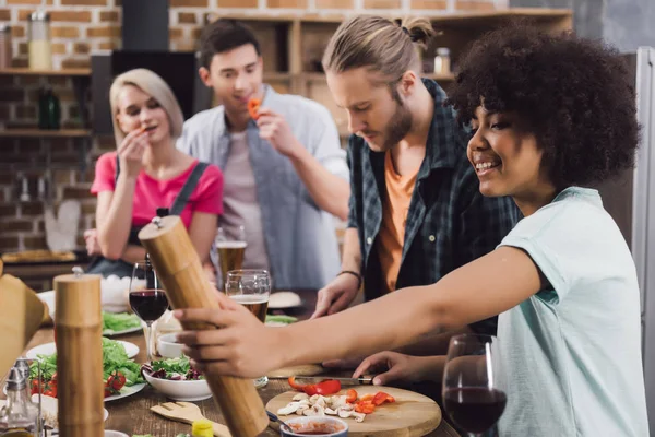 Multiethnic friends preparing food together in kitchen — Stock Photo