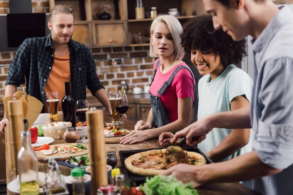 Multikulti-Freunde bereiten zu Hause Pizza zu — Stockfoto