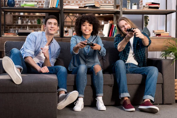 Amici multiculturali che giocano ai videogiochi a casa — Foto stock