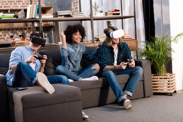Amis multiculturels jouer à un jeu vidéo avec des casques de réalité virtuelle — Photo de stock