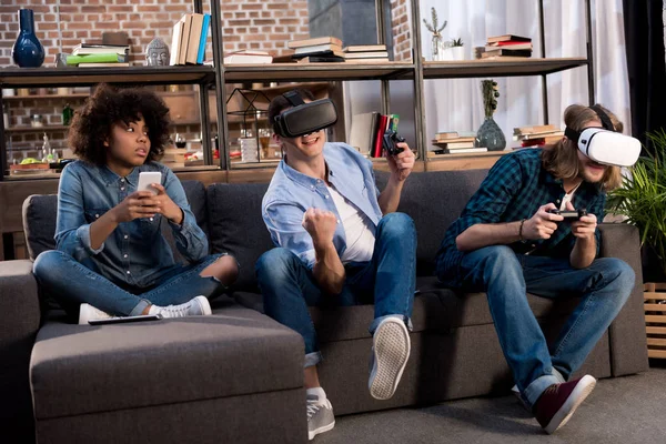 Freunde spielen Videospiel mit Virtual-Reality-Headsets, afrikanisches amerikanisches Mädchen sitzt mit Smartphone — Stockfoto