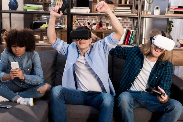 Amigos jogando vídeo game com fones de ouvido realidade virtual — Fotografia de Stock