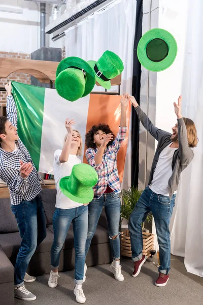 Amigos multiculturais vomitando chapéus verdes no dia patricks — Fotografia de Stock