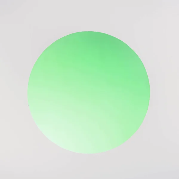 Круглая зеленая дыра с копировальным пространством на сером — стоковое фото