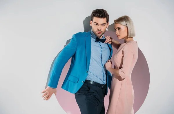 Jeune couple à la mode posant ensemble dans le trou sur gris — Photo de stock