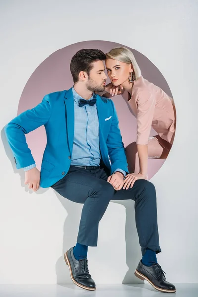 Belo casal jovem na moda posando juntos no buraco no cinza — Fotografia de Stock