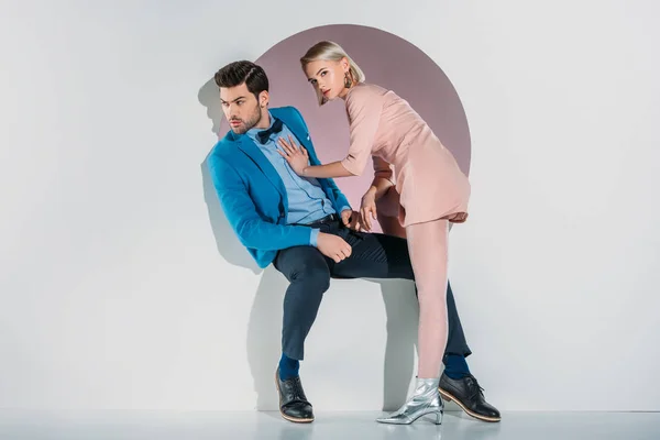 Jovem casal na moda posando juntos em abertura no cinza — Fotografia de Stock