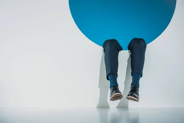 Section basse de élégant jeune homme tombant dans le trou sur gris — Photo de stock