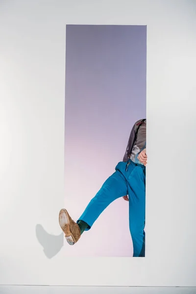 Cropped shot of stylish man walking through opening on grey — Stock Photo