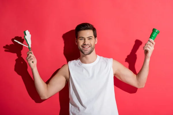 Schöner junger Fan jubelt mit Accessoires auf rosa — Stockfoto