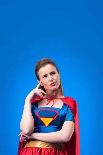 Ritratto di donna pensierosa in costume da supereroe che distoglie lo sguardo isolato sul blu — Foto stock