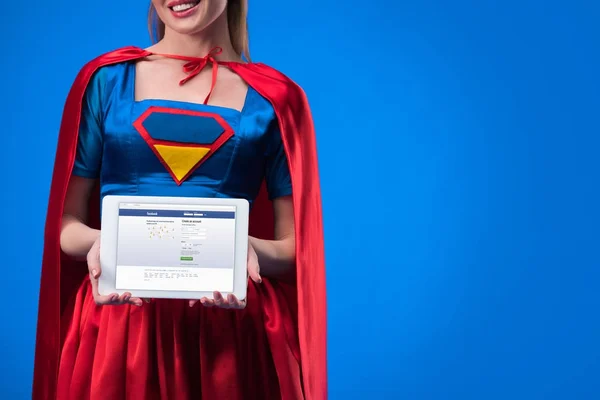 Vue partielle de la femme en costume de super-héros montrant tablette isolée sur bleu — Photo de stock