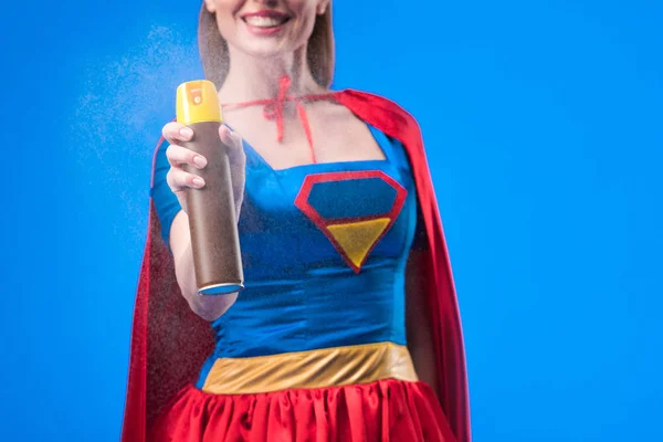 Visão parcial de super-mulher sorridente com detergente na mão isolado em azul — Fotografia de Stock