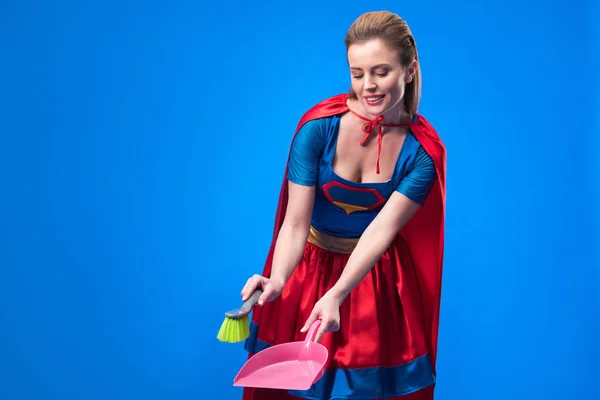 Portrait de femme en costume de super héros avec balai et cuillère pour le nettoyage isolé sur bleu — Photo de stock