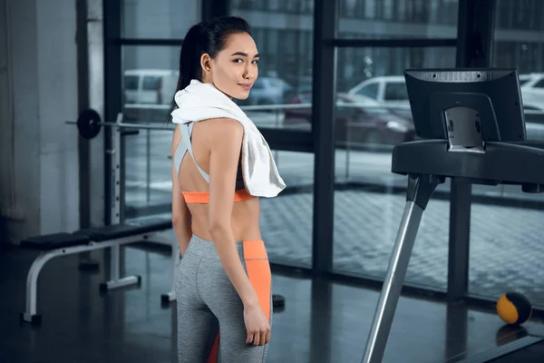 Jeune femme sportive avec serviette sur les épaules à la salle de gym — Photo de stock