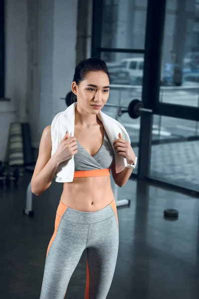 Junge sportliche Frau mit Handtuch auf den Schultern im Fitnessstudio — Stockfoto