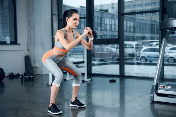 Junge sportliche Frau macht Kniebeugen im Fitnessstudio — Stockfoto